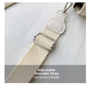 Detail of adjustable woven shoulder strap with silver metal buckle on a beige square bag