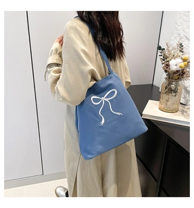 Détail du cabas bleu en toile avec broderie nœud blanc et fermeture éclair sécurisée