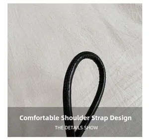 Détail de la bandoulière en cuir noir confortable sur un sac seau de style minimaliste