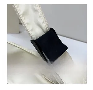 Detail of adjustable black buckle and premium zipper on cream commuter tote bag