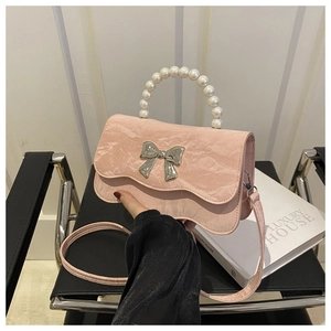 Detail der rosa Tasche mit Marmormuster, Perlengriff und silberner Bogenschließe
