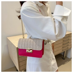 Detail view of woven straw flap and pink leather panel with gold chain strap on shoulder bag