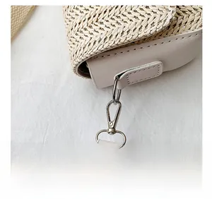 Detailed close-up of woven texture, leather stitching, and silver metal hardware on bag