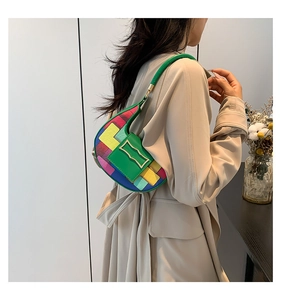 Detail of colorful patchwork crescent underarm bag with unique gold metal clasp