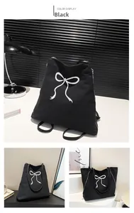 Détail du grand sac cabas en toile noire avec broderie nœud blanc et fermeture éclair