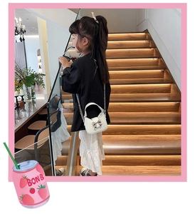 Mini borsa a tracolla bianca per bambina con fiocco in metallo indossata da modella