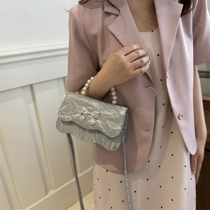 Silberne gefaltete Umhängetasche mit Perlengriff und Schleifendekor für elegante Frauen