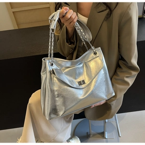 Detail of silver tote bag with crinkle texture leather and metal chain strap