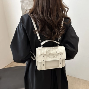 Elegante mochila de PU blanco crema con motivo de corazón y lazos en una modelo mujer