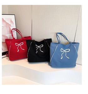 Détails des sacs fourre-tout en toile rouge, noir et bleu avec imprimés nœuds