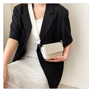 Detail showing beige woven texture and white leather patchwork on a small crossbody bag