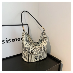 Détail du sac seau avec imprimés floraux rétro et finitions en métal doré élégant
