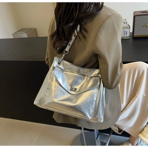Detail of a large silver tote bag with metallic texture and a rectangular metal turn-lock