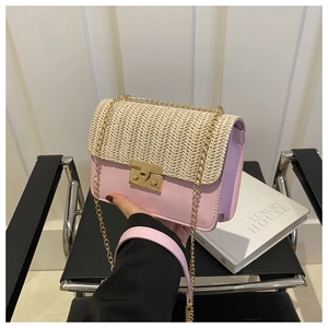 Close-up of pink leather and straw woven bag featuring a gold clasp and metal chain strap