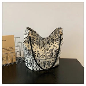 Détail du sac cabas à motif floral noir et blanc avec des ferrures métalliques dorées