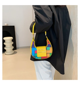 Detail view of a colorful geometric pattern mini handbag worn by a model in a modern room