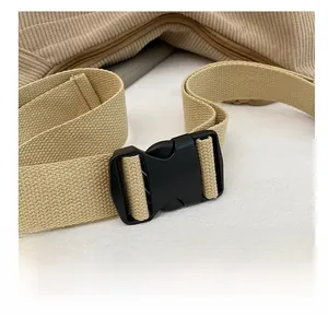 Close-up of corduroy crossbody bag with durable plastic buckle and canvas strap