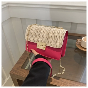Close-up of woven straw texture and pink leather detail with golden metal buckle on bag