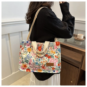 Floral canvas tote bag details showing shoulder strap and side view on a female model