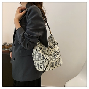 Détail du sac hobo imprimé avec motifs floraux vintage et bandoulière en cuir noir
