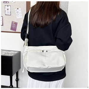 Detailed back view of white nylon messenger bag with double zipper pockets and strap