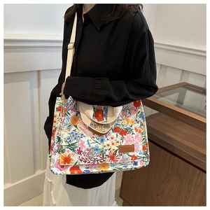 Detail of floral canvas tote bag showing the fashion leather patch and colorful pattern