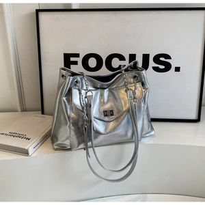 Detail of silver metallic tote bag with pleated texture and stylish metal chain strap