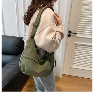 Detail of olive green corduroy hobo bag showing adjustable strap and texture on model