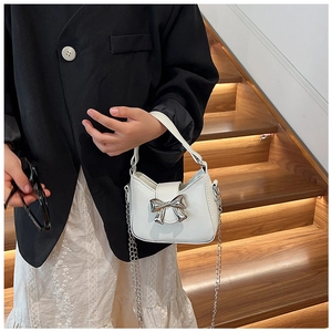 Piccola borsa bianca per bambina con fiocco in metallo argento indossata da modella