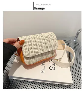 Detail of the orange woven crossbody bag with white straw texture and canvas strap