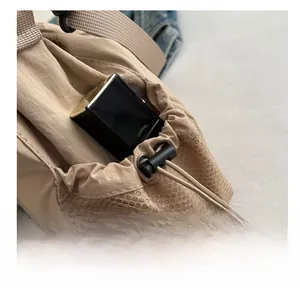 Macro shot of nylon shoulder bag side mesh pocket with Fashion label and beige texture