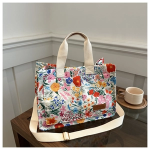 Detail of floral canvas tote bag showing front pockets and leather fashion label tag