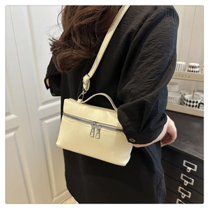 Close-up of cream white lychee pattern leather bag with silver double zipper and strap