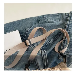 Detail showing adjustable nylon shoulder strap with black buckle and hardware hook