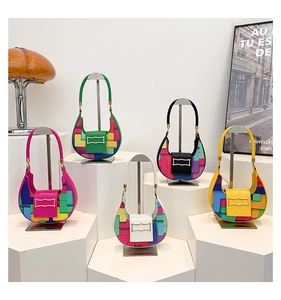 Detail showing colorful geometric patchwork handbags and wavy metal buckles on display