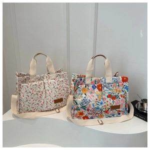 Detailed view of floral canvas tote bags with double pockets and leather fashion label