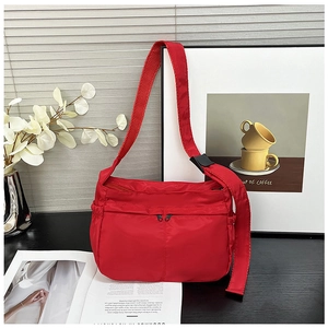 Detail of red nylon tote bag featuring front vertical zippers and waterproof woven texture
