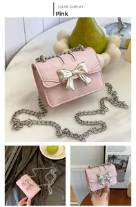 Close-up of pink mini crossbody bag featuring a silver metal bow and textured chain strap