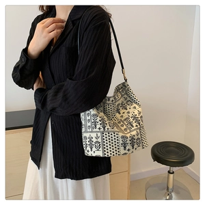 Détail du sac en toile blanche avec imprimé floral noir vintage et fine bandoulière