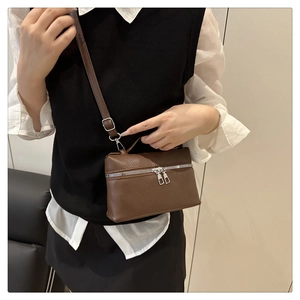 Brown litchi texture leather crossbody bag shown with a silver zipper on a model