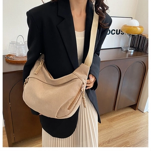 Detail view of beige corduroy crescent bag showing fabric texture and braided zipper pull