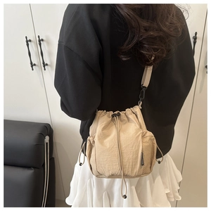 Detail view of khaki nylon bucket bag with side mesh pocket and adjustable shoulder strap