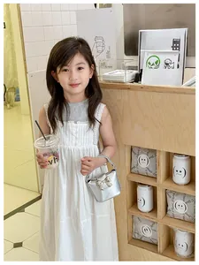 Dettaglio di una bambina con una mini borsa argento e decorazione a fiocco dorato