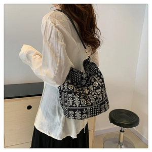 Détail d'un sac cabas vintage avec motif floral blanc sur toile noire