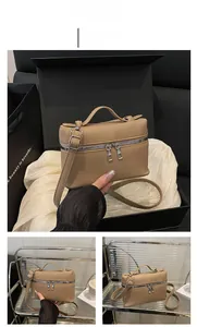 Detailed macro view of khaki lychee grain leather handbag with silver metal zippers