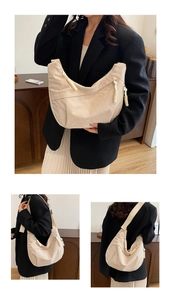 Detail view of corduroy dumpling bag featuring cotton rope tassel and textured fabric