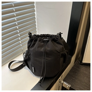 Detail view of durable black nylon crossbody bag featuring a FASHION label and side pocket
