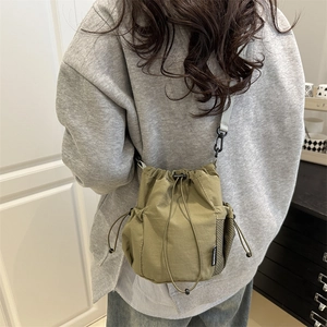 Olive green nylon drawstring bucket bag with side mesh pocket and fashion label