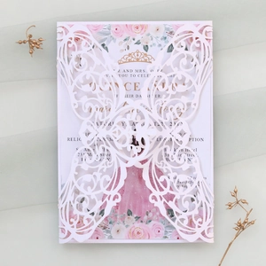 Détail de l'invitation découpée au laser avec roses roses et imprimés couronne dorée