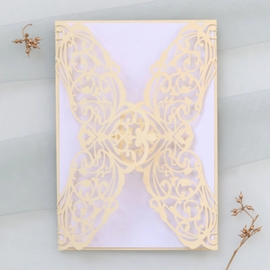 Détail de l'invitation de mariage ivoire découpée au laser avec motif floral élégant